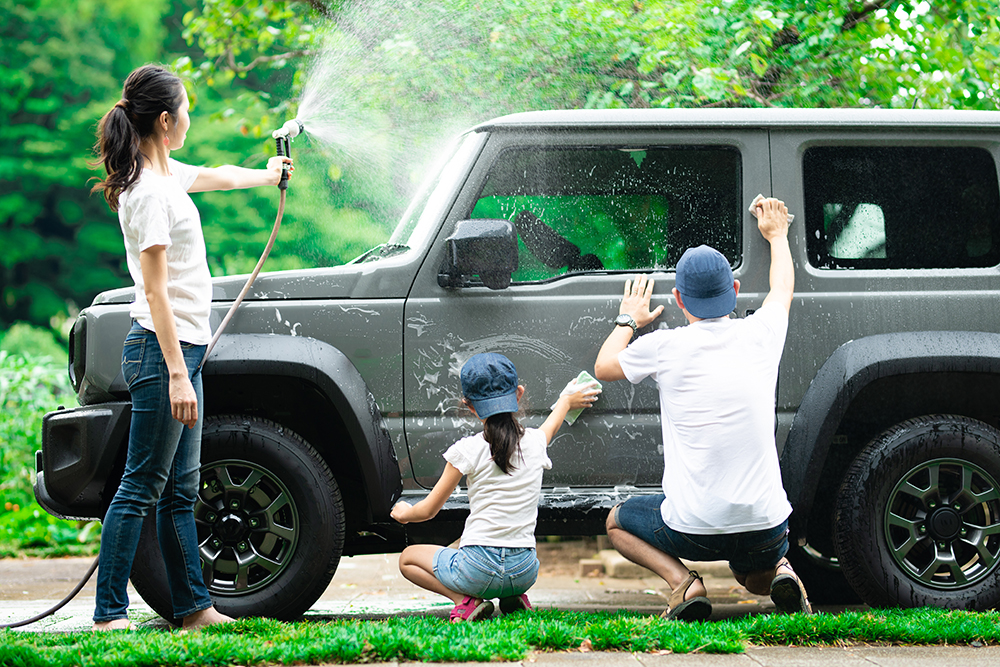 ガレージハウス前で愛車を洗車する家族